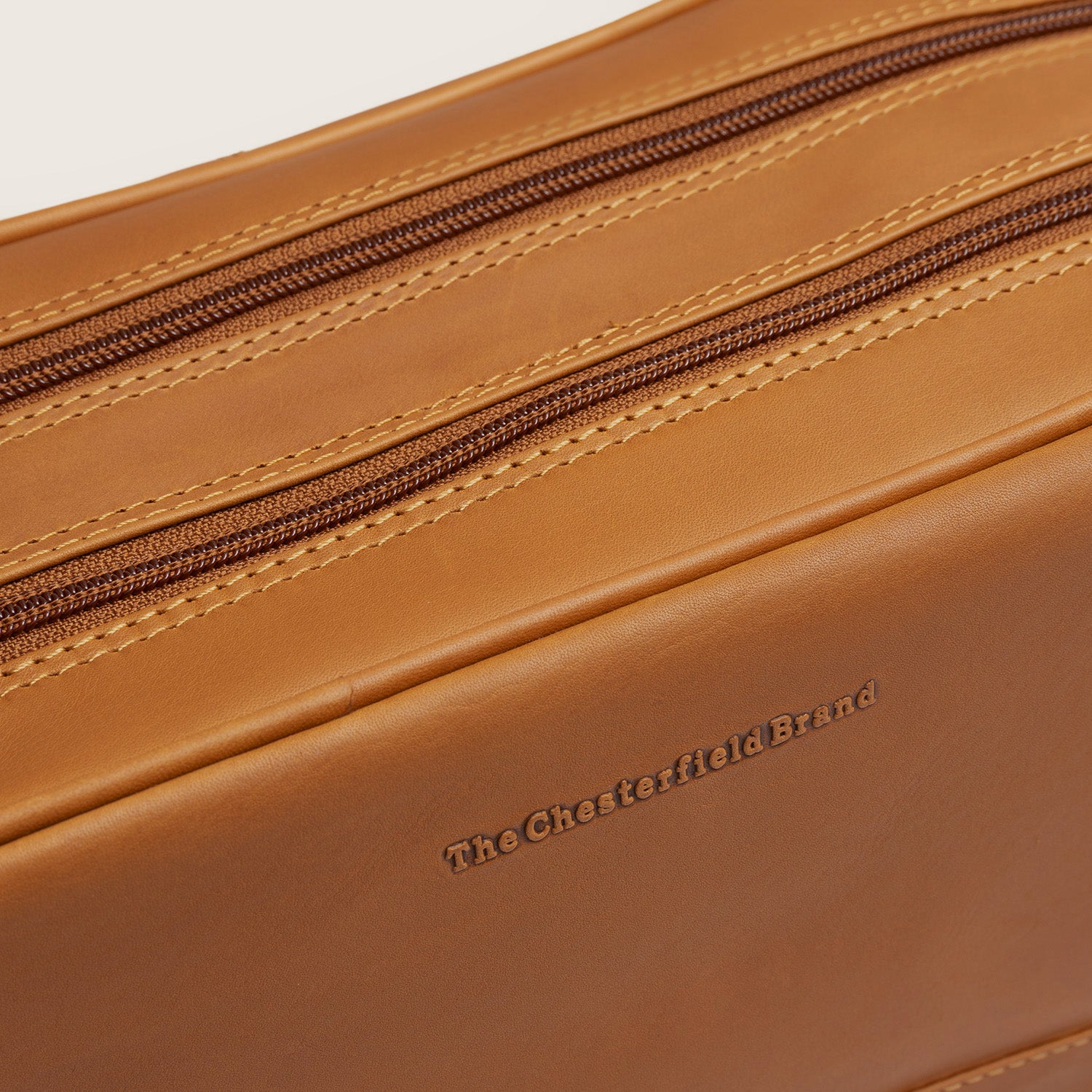 Leren Toilettas Cognac Stefan, close-up van het ingeperste logo
