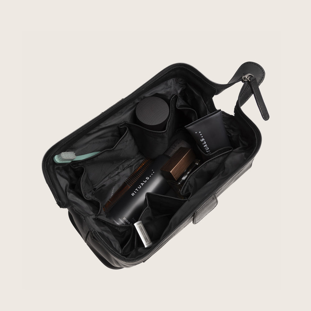 Trousse de Toilette en Cuir Noir Vince, compartiment principal ouvert, avec articles de toilette