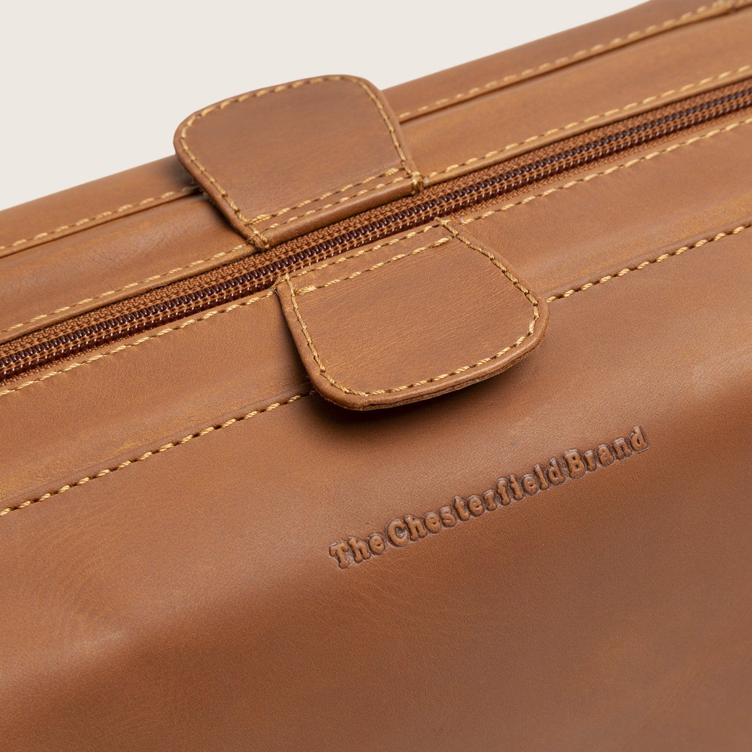 Leren Toilettas Cognac Vince, close-up van het ingeperste logo