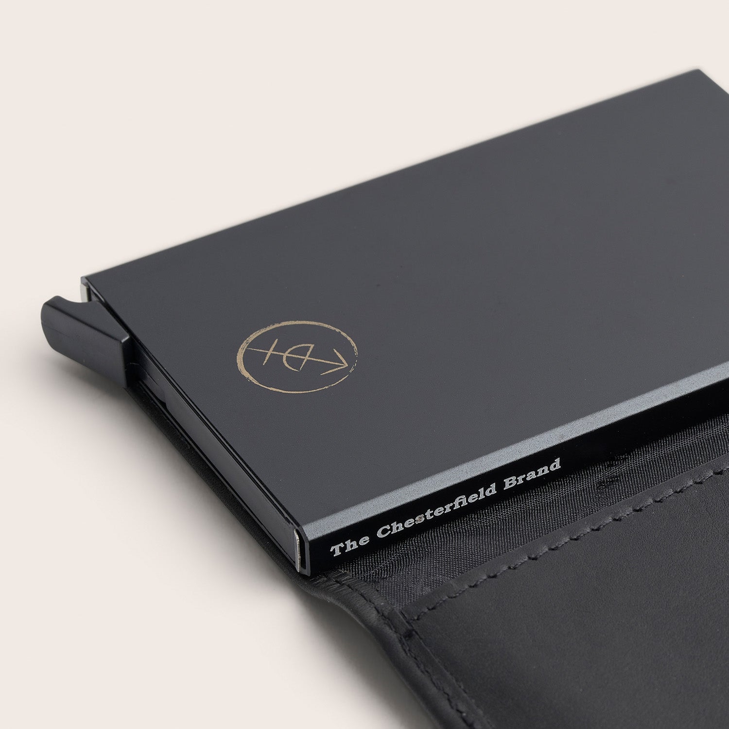 Porte-cartes en Cuir Noir Leicester, gros plan sur l'étui à cartes en métal avec l'inscription 'The Chesterfield Brand'