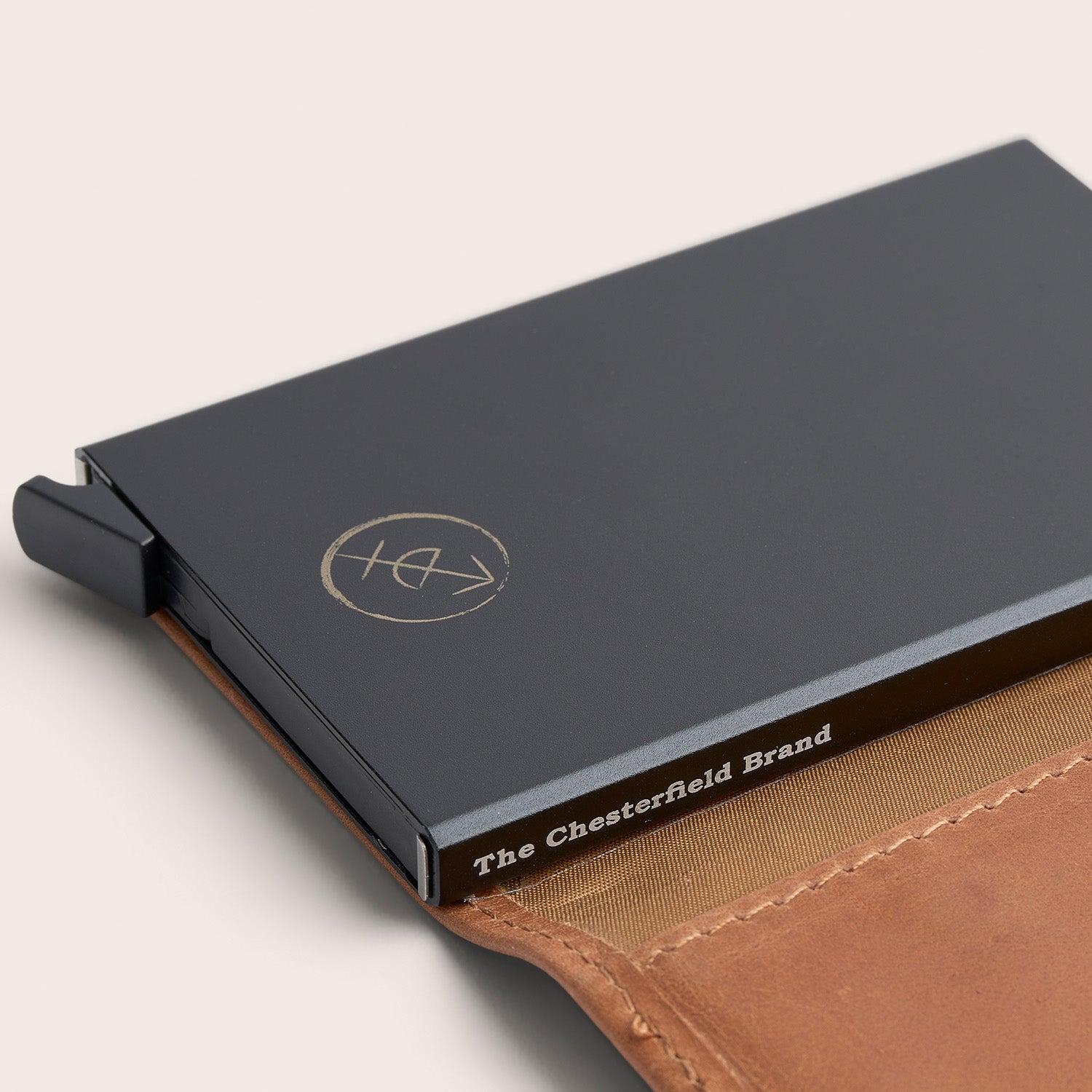 Porte-cartes en Cuir Cognac Leicester, gros plan sur l'étui à cartes en métal avec l'inscription 'The Chesterfield Brand'
