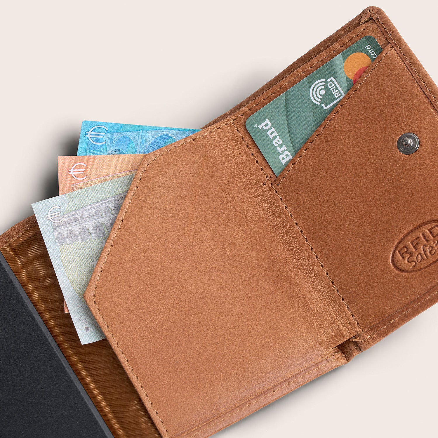 Leather Card Holder Cognac Palma, inside view, opened, with a card and banknotes, embossed 'RFID Safe'