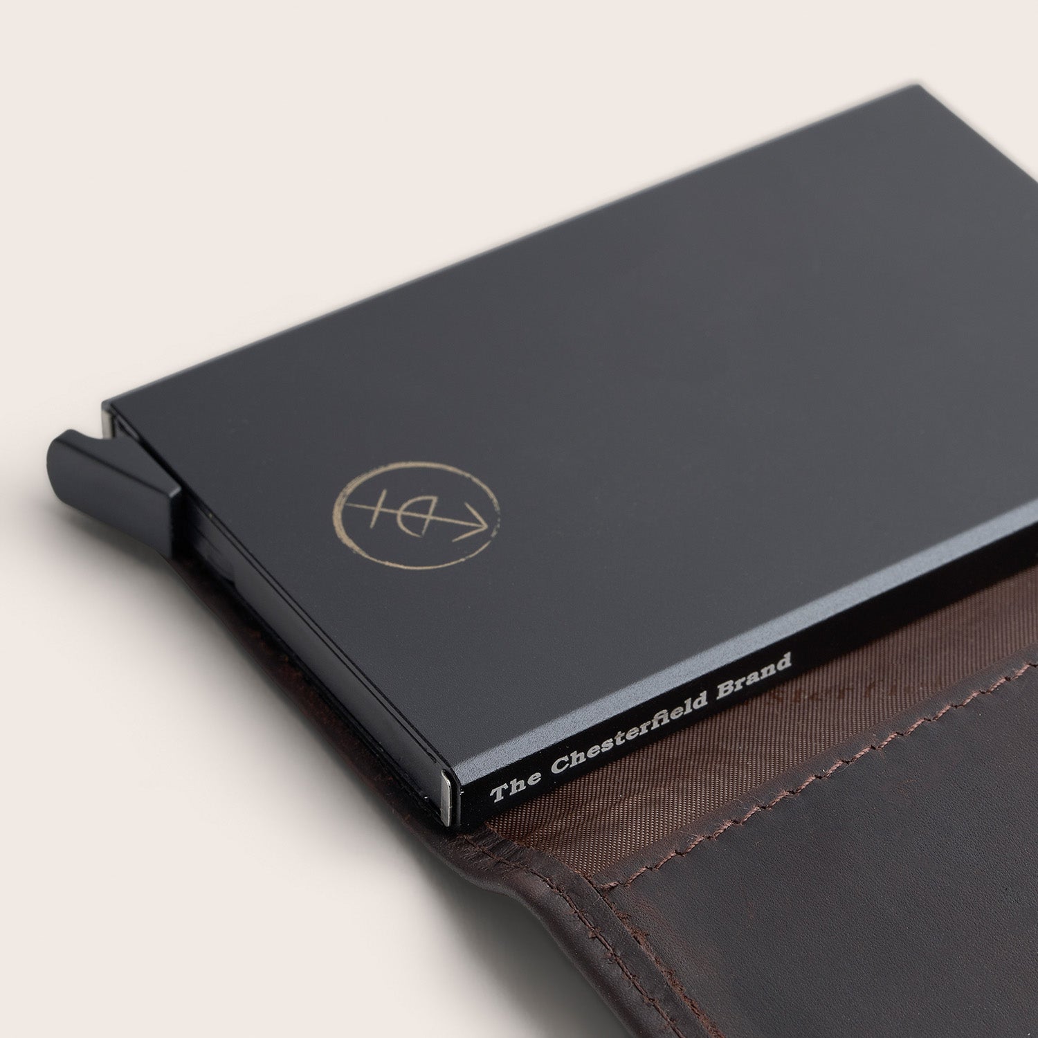 Porte-cartes en Cuir Marron Frankfurt, gros plan sur le mécanisme à cartes noir avec l'inscription 'The Chesterfield Brand'