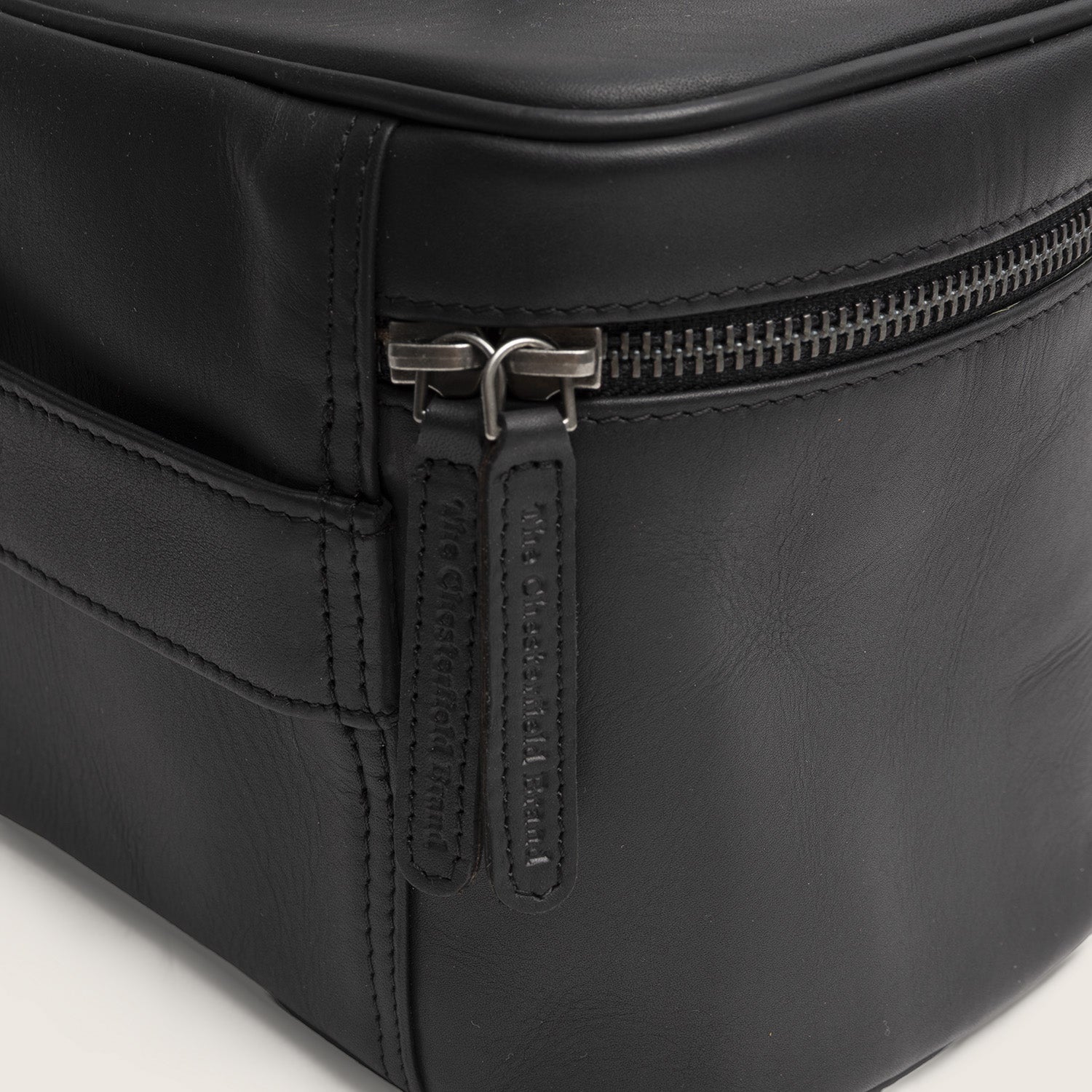 Trousse de Toilette en Cuir Noir Limone, gros plan sur les tirettes avec 'The Chesterfield Brand' embossé