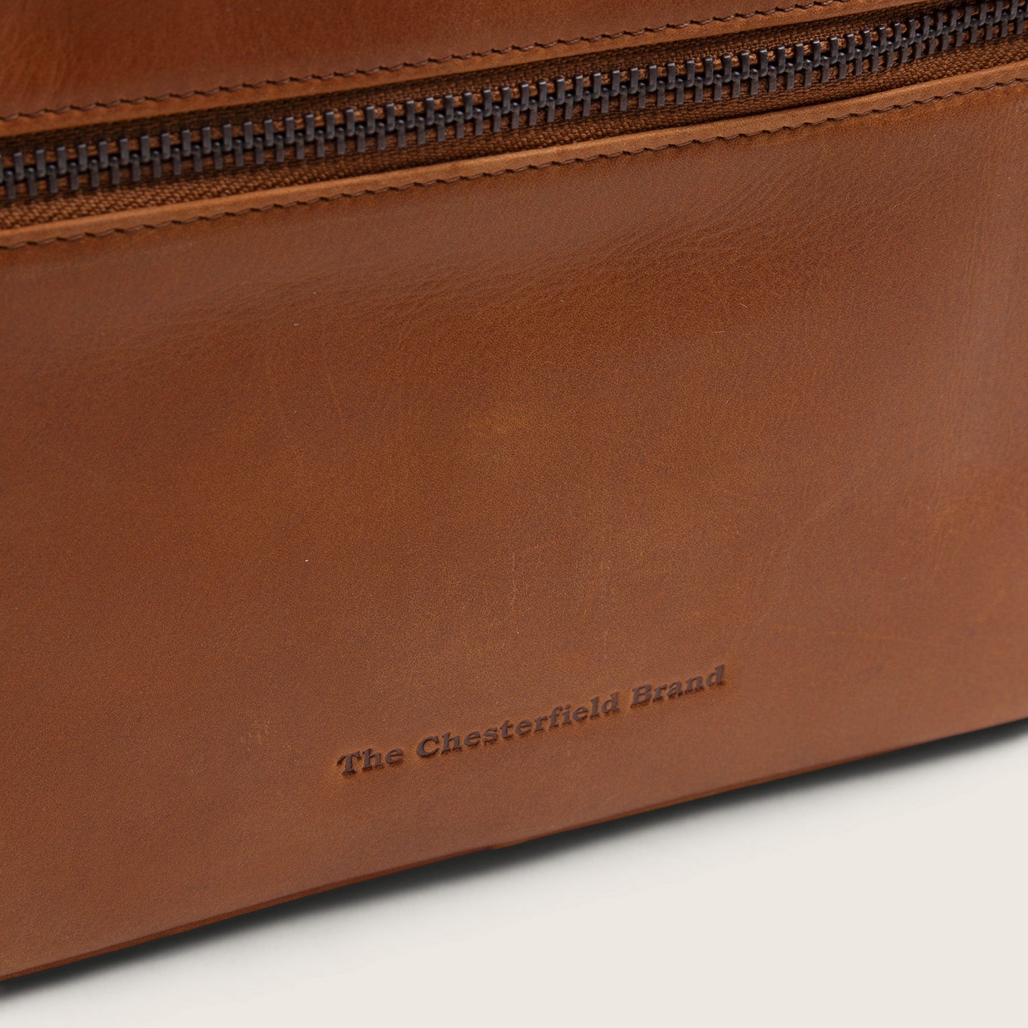Leren Toilettas Cognac Limone, close-up van het ingeperste logo 'The Chesterfield Brand'