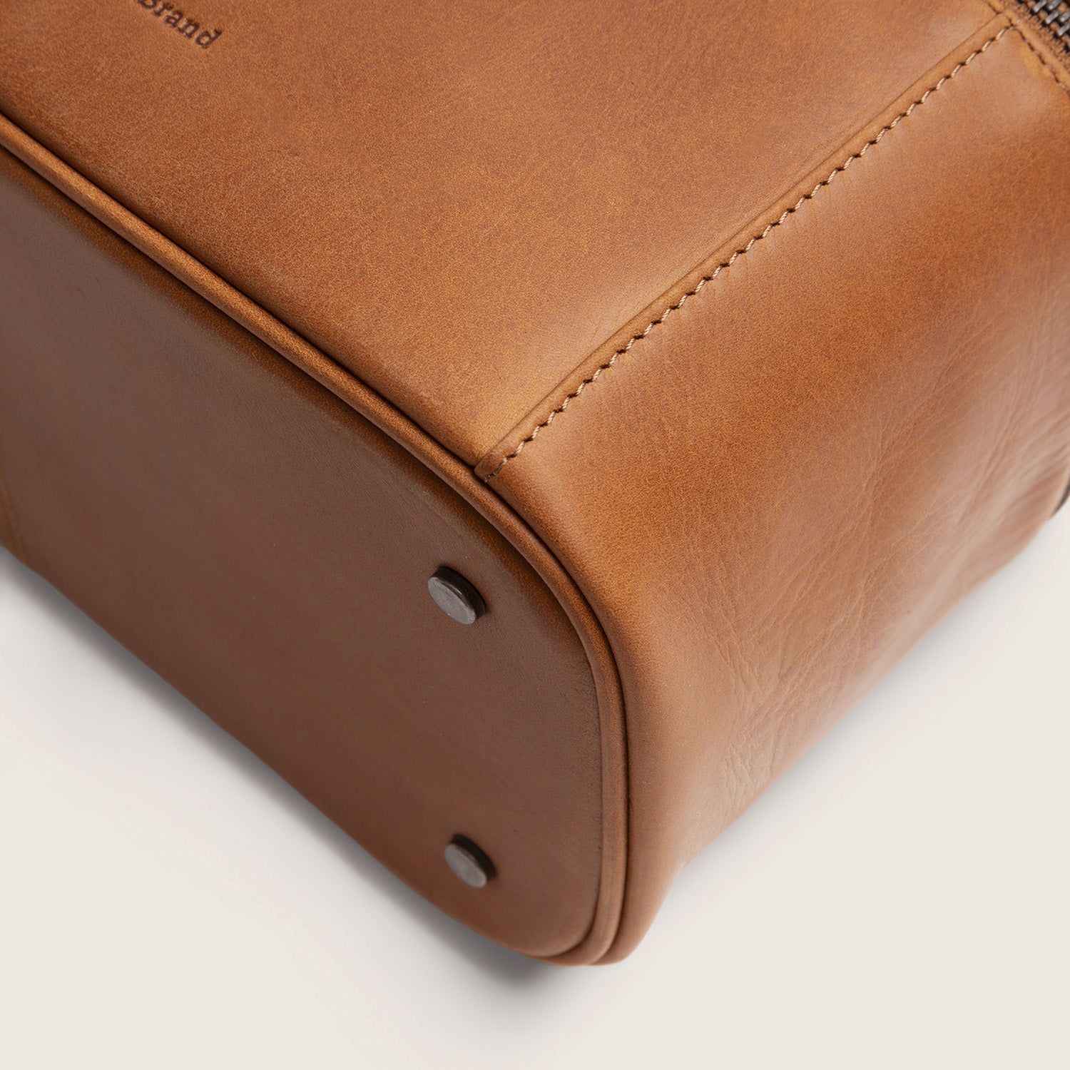 Leren Toilettas Cognac Limone, close-up van de onderkant met metalen voetjes