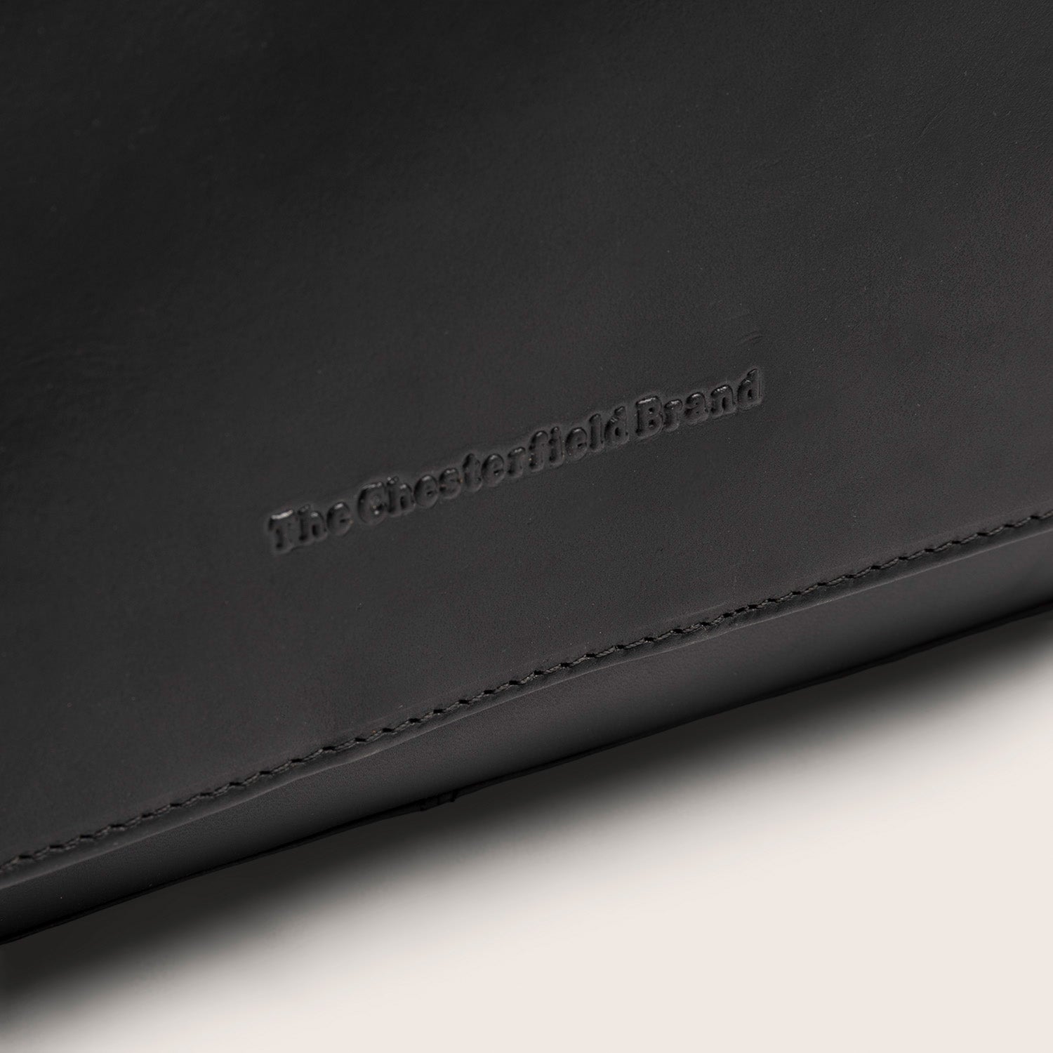 Leder Kulturtasche Schwarz Rosario, Nahaufnahme des geprägten Logos