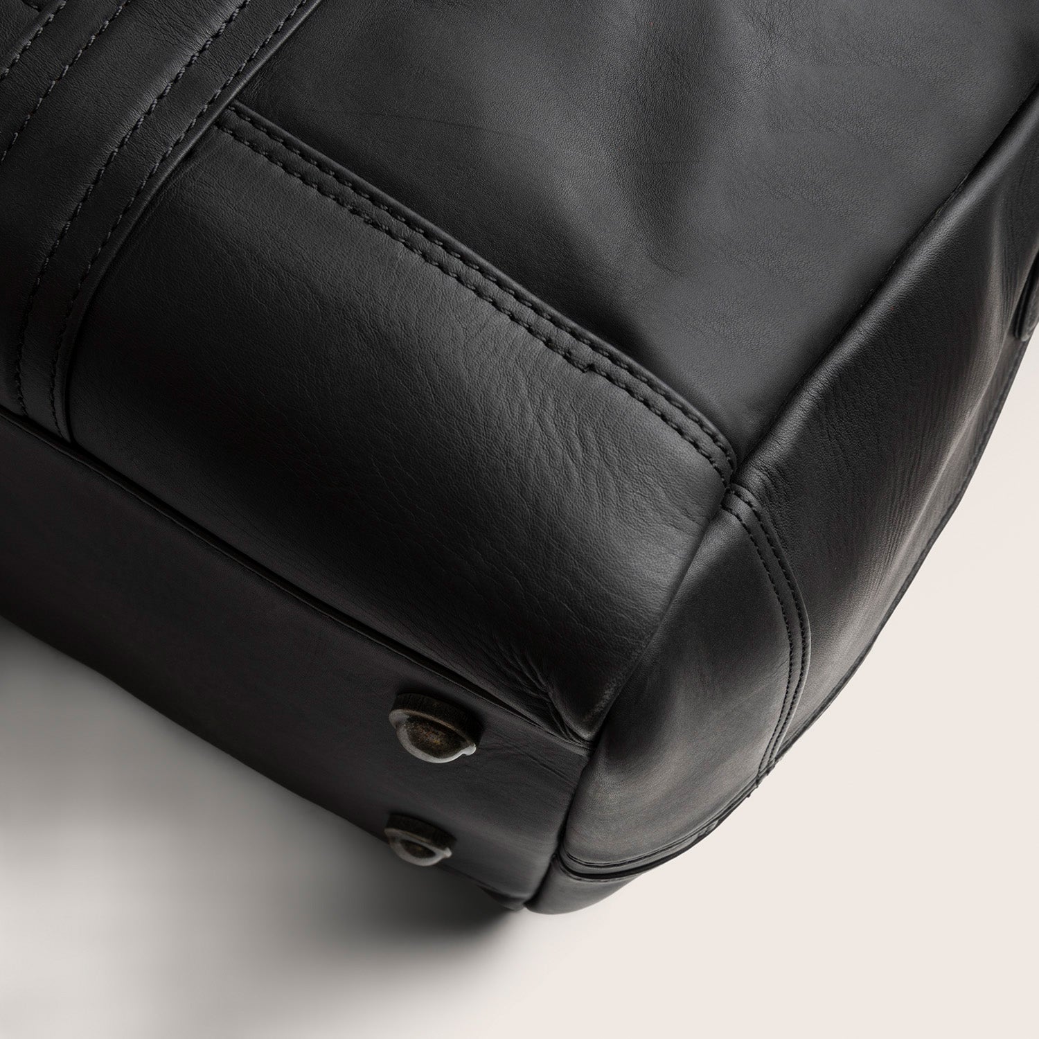 Sac Week-end en Cuir Noir Perth, gros plan sur le fond avec pieds métalliques