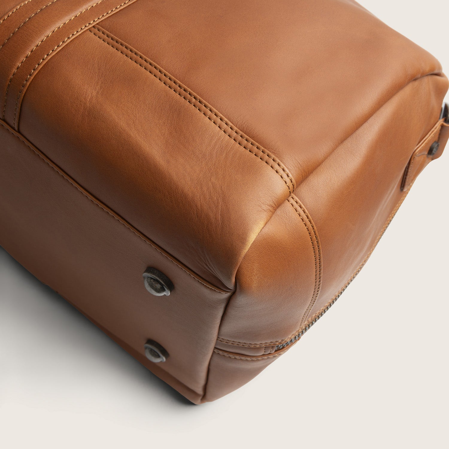 Leather Weekender Bag Cognac Melbourne, close-up of the base with metal feet