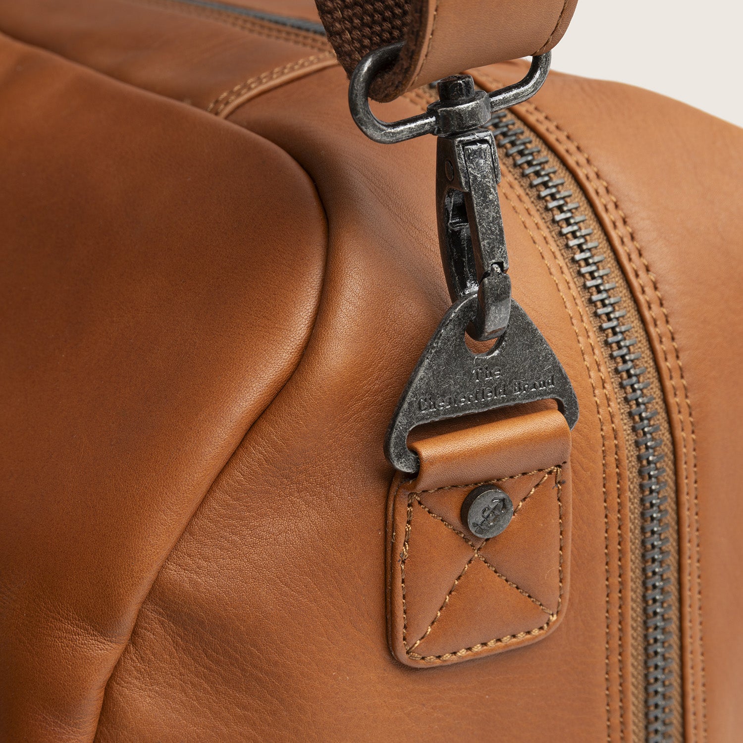 Leather Weekender Bag Cognac Melbourne, close-up of the shoulder strap fitting, engraved 'The Chesterfield Brand'