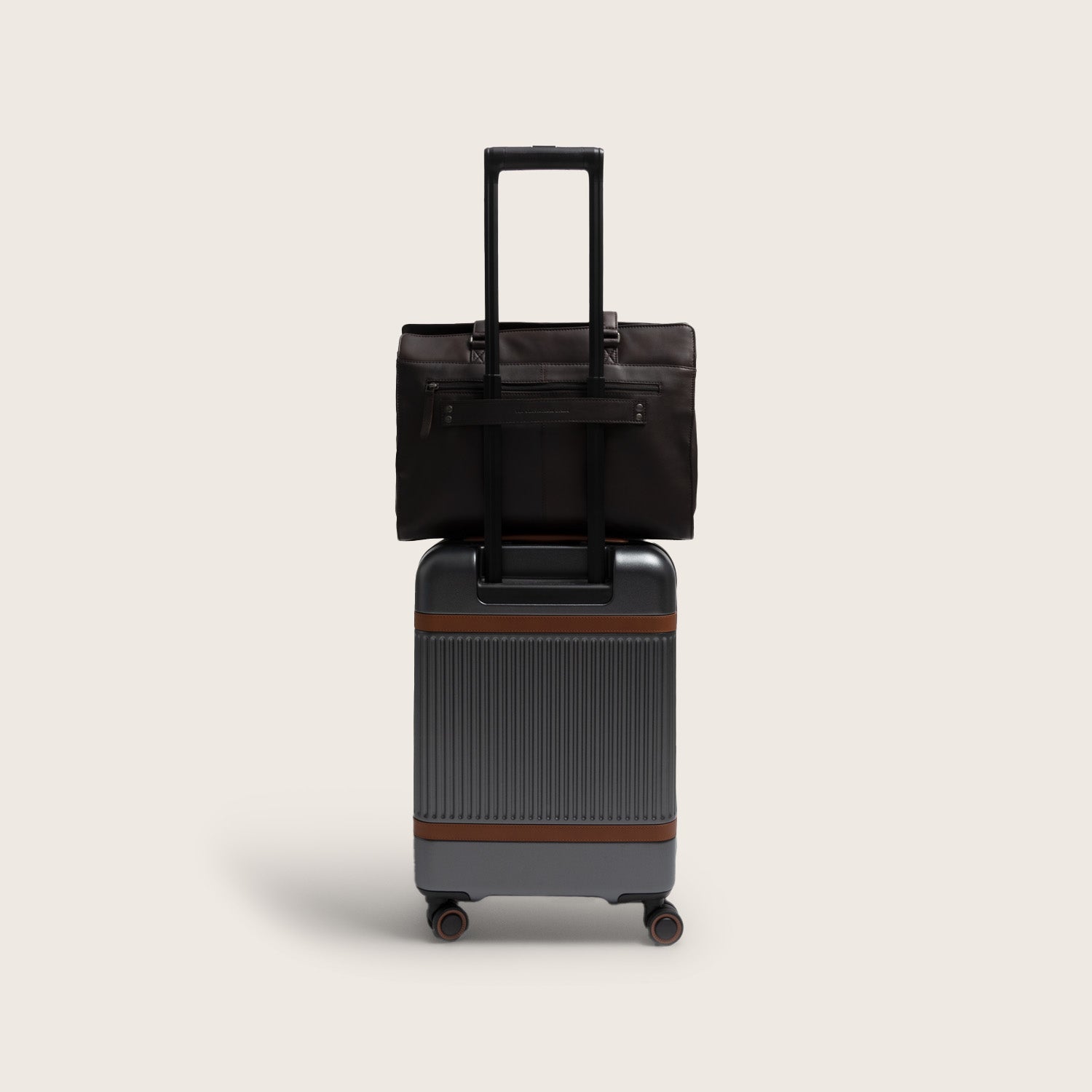 Leather Shoulder Bag Brown Fidenza, slid over the handle of a suitcase