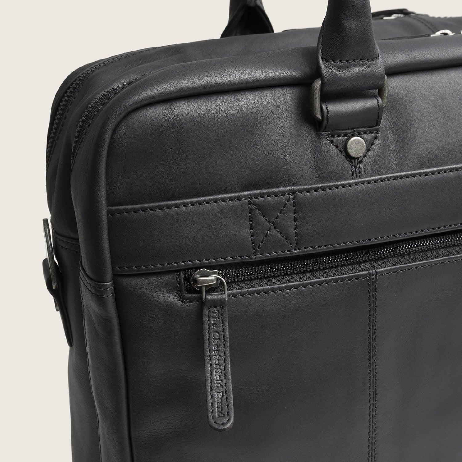 Leren Laptoptas Zwart Boston, close-up van het ritsvak en de trolleyband op de achterkant