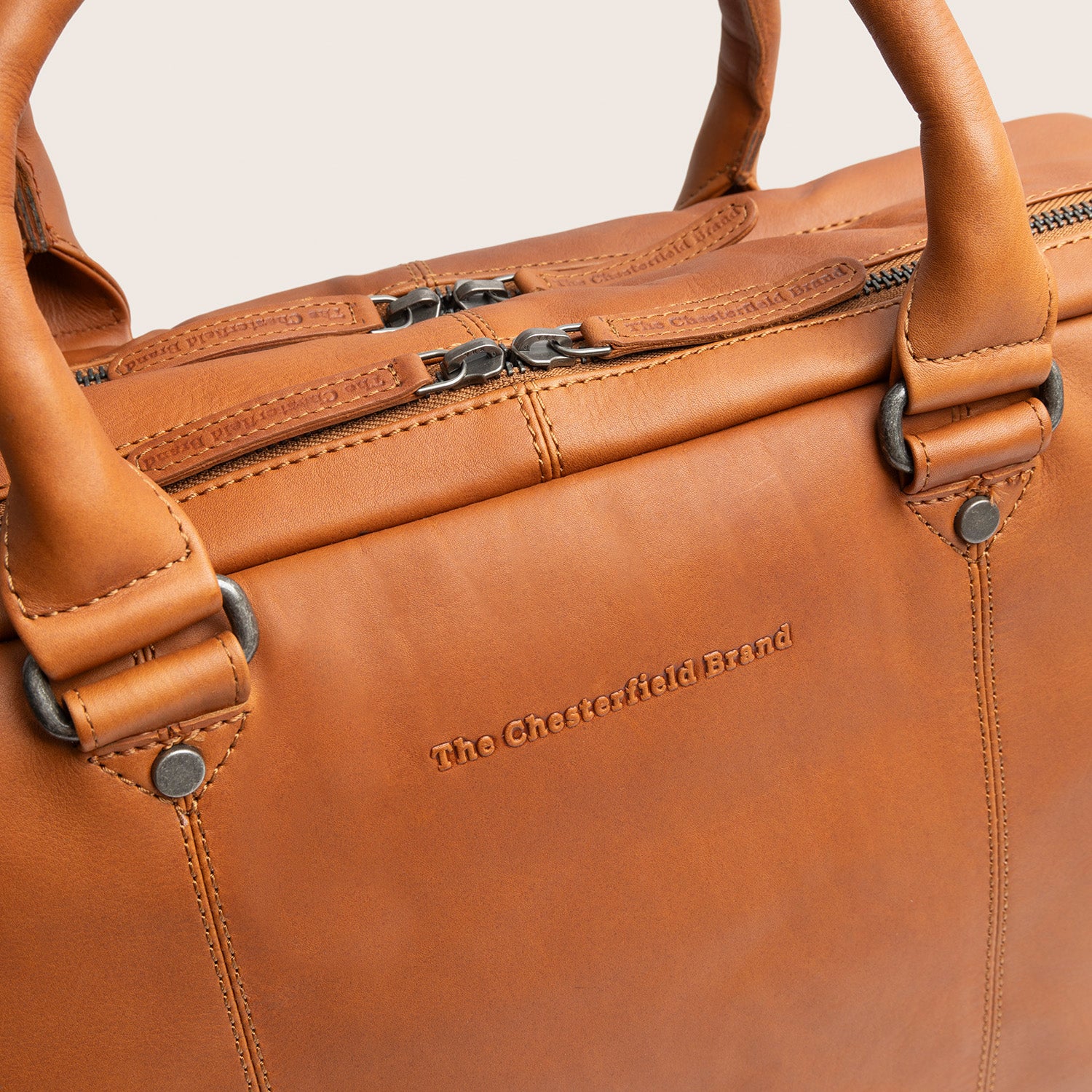 Sacoche Ordinateur en Cuir Cognac Boston, gros plan sur le logo embossé