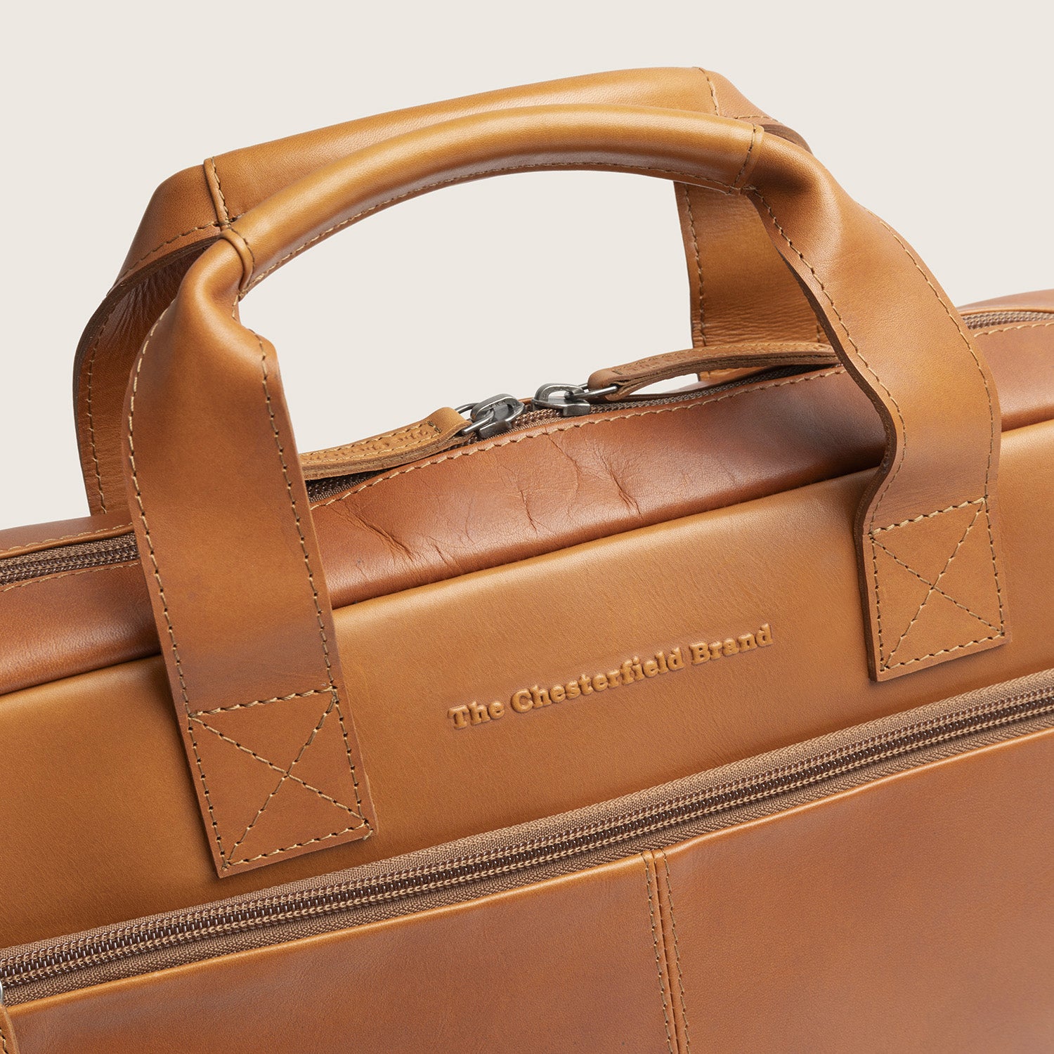Leren Laptoptas Cognac Calvi, close-up van de handvatten en het ingeperste logo