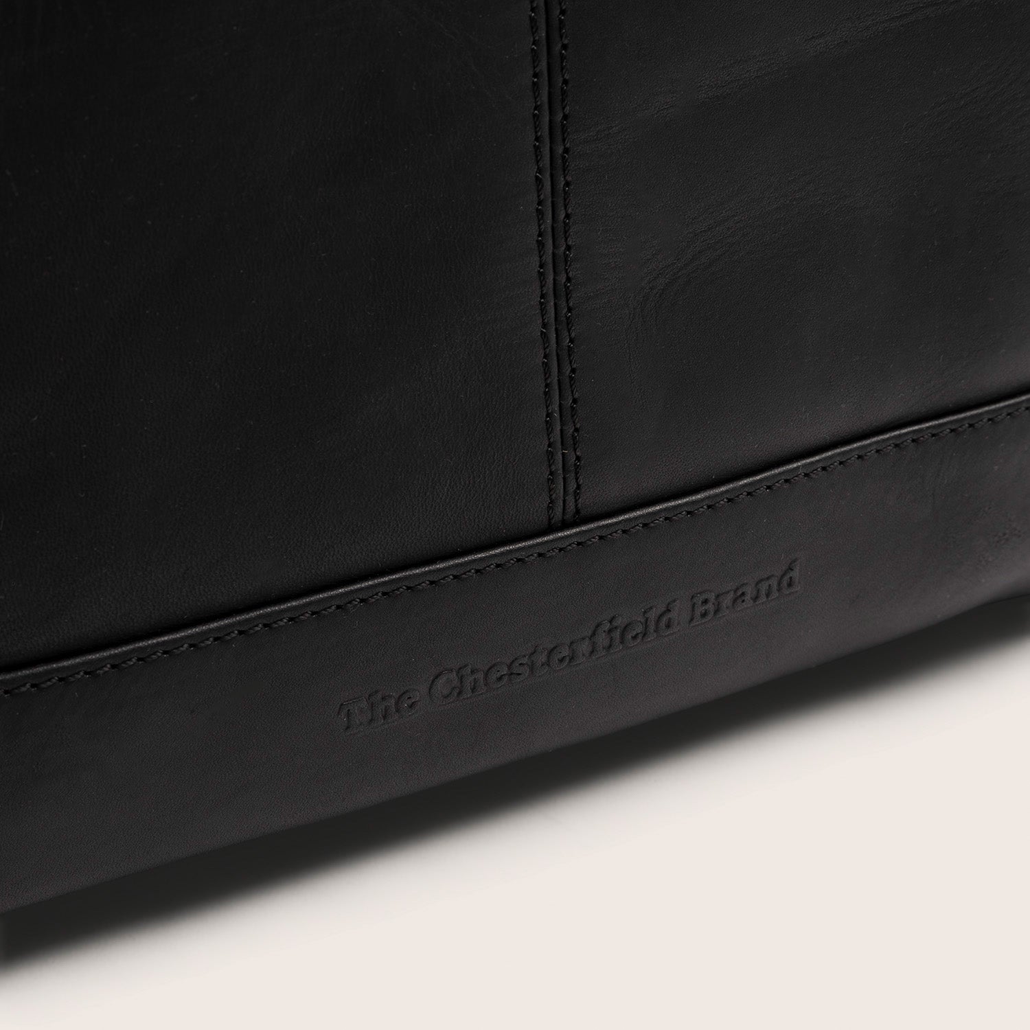 Leder Rucksack Schwarz Manchester, Nahaufnahme des geprägten Logos 'The Chesterfield Brand'