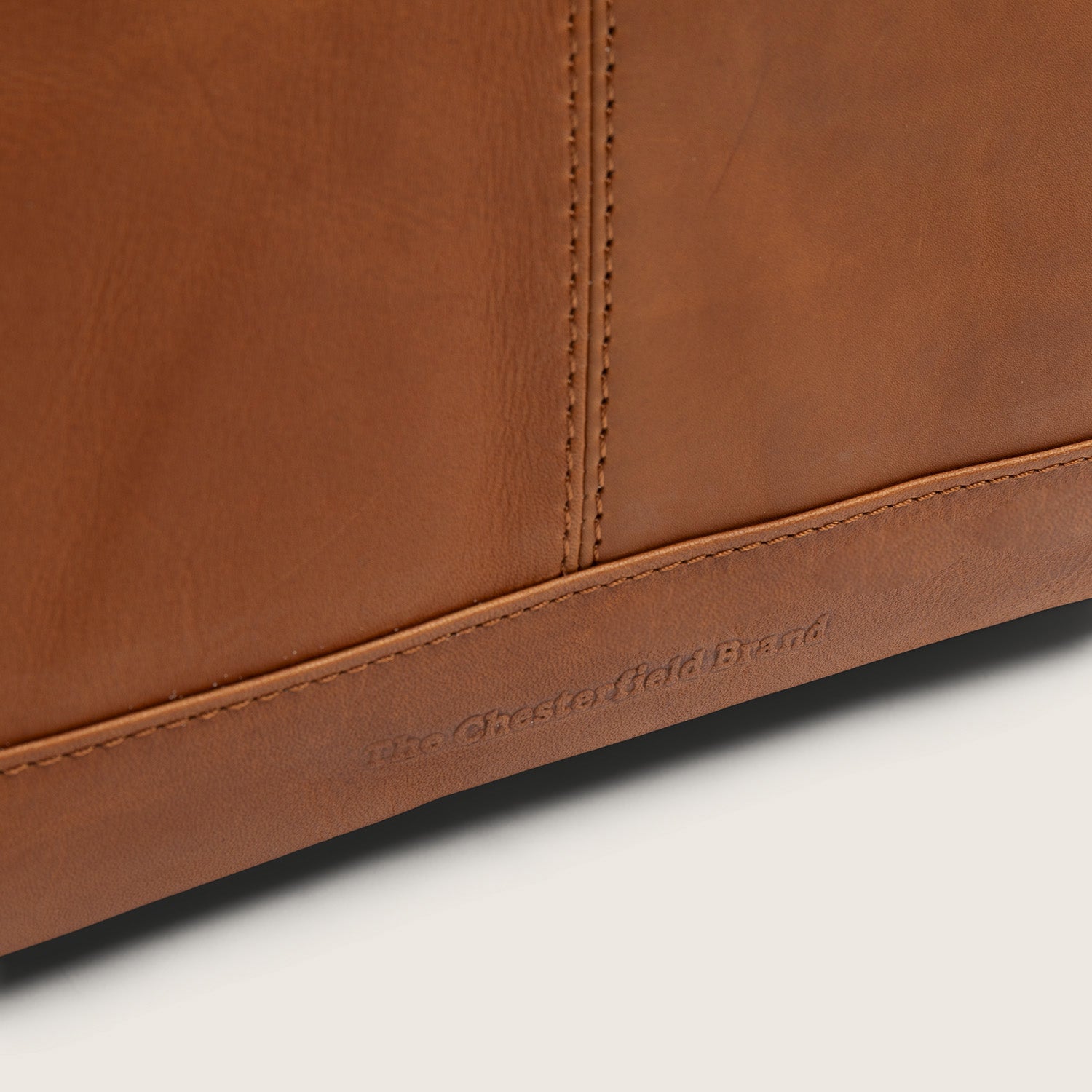 Sac à Dos en Cuir Cognac Manchester, gros plan sur le logo embossé 'The Chesterfield Brand'