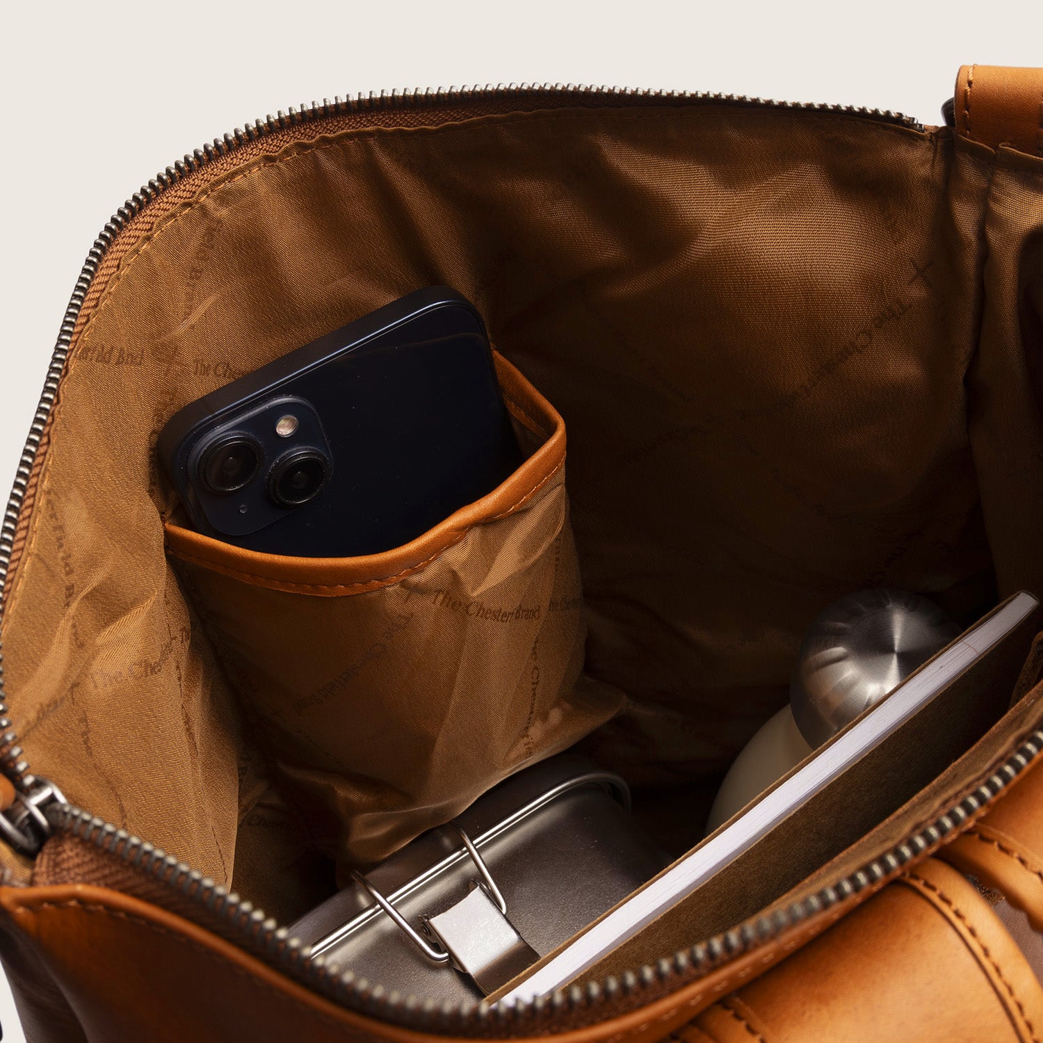 Sac à Dos en Cuir Cognac Manchester, compartiment principal ouvert, avec téléphone dans la poche intérieure