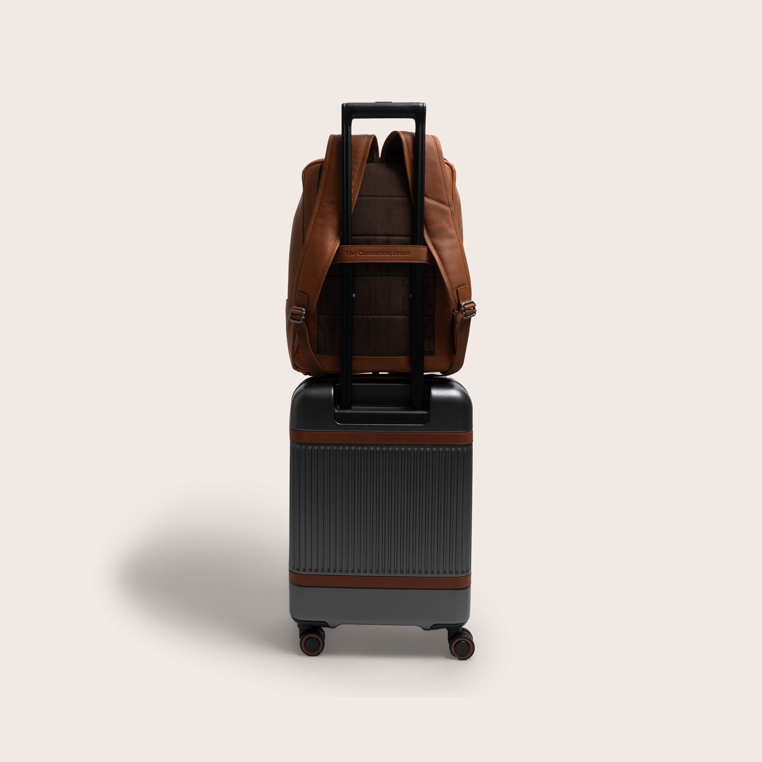 Leather Laptop Backpack Cognac Rich, attached to a suitcase with the trolley strap