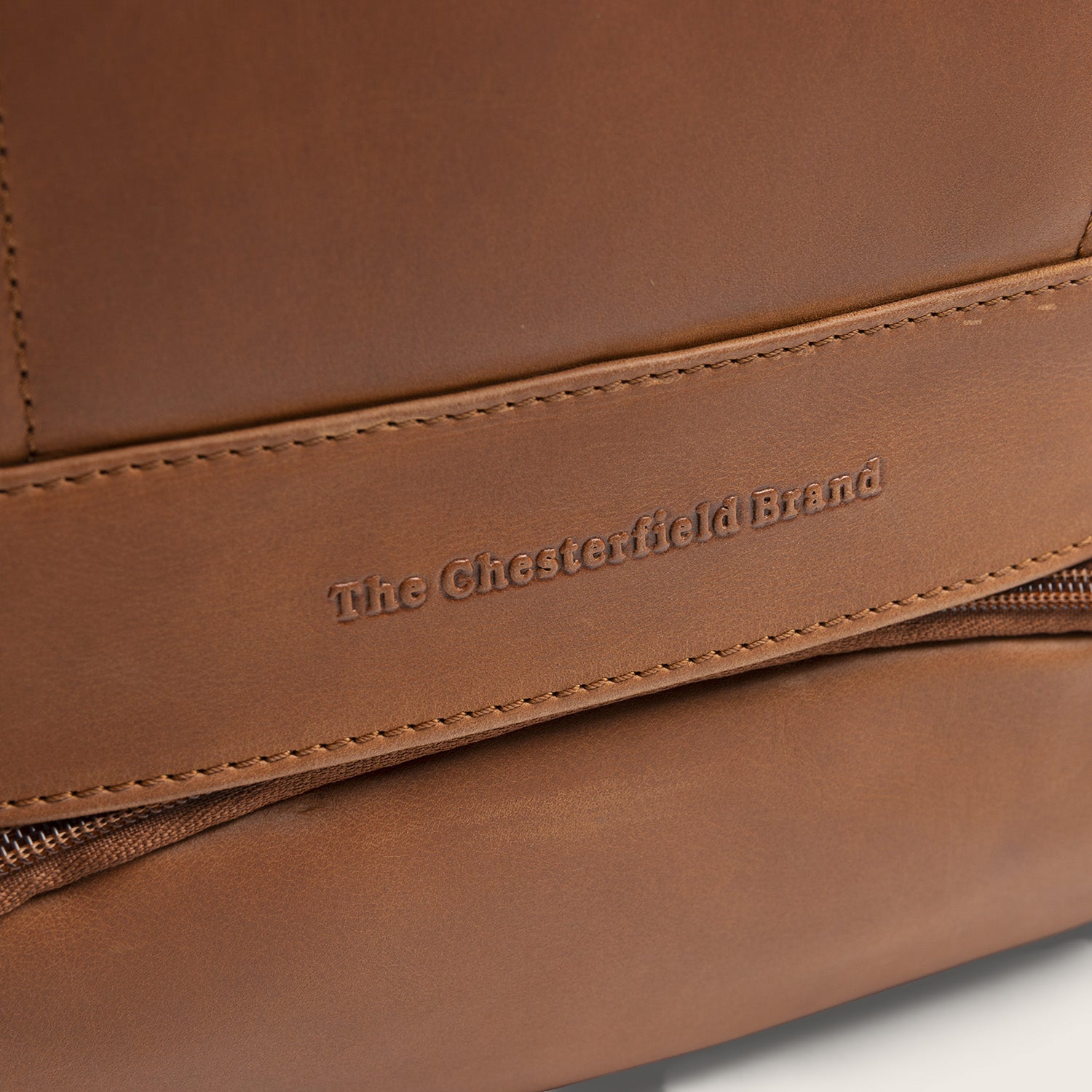 Leather Laptop Backpack Cognac Rich, close-up of the embossed logo