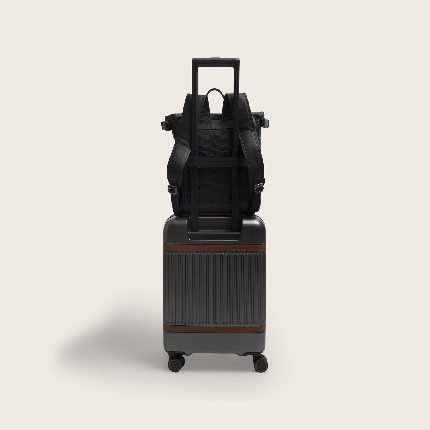Leather Roll-top Backpack Black Mazara, on a suitcase with the trolley strap