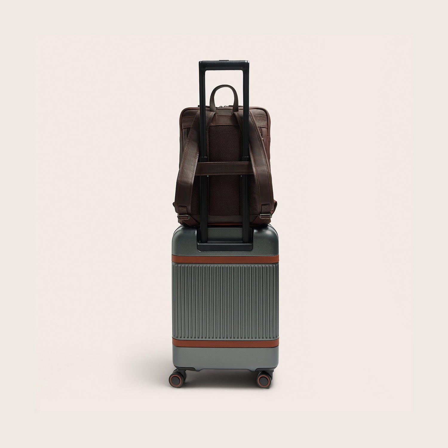 Leather Laptop Backpack Brown Jasper, back view, on a suitcase handle via the trolley strap