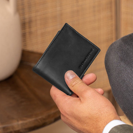 Man holding a black leather billfold