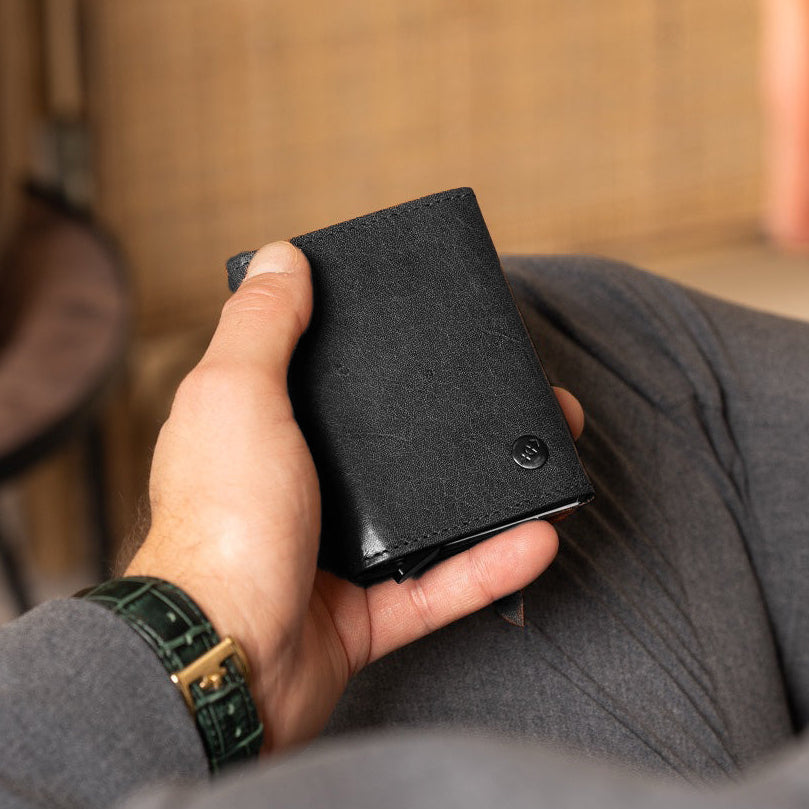 Person holding a black wallet in a casual setting