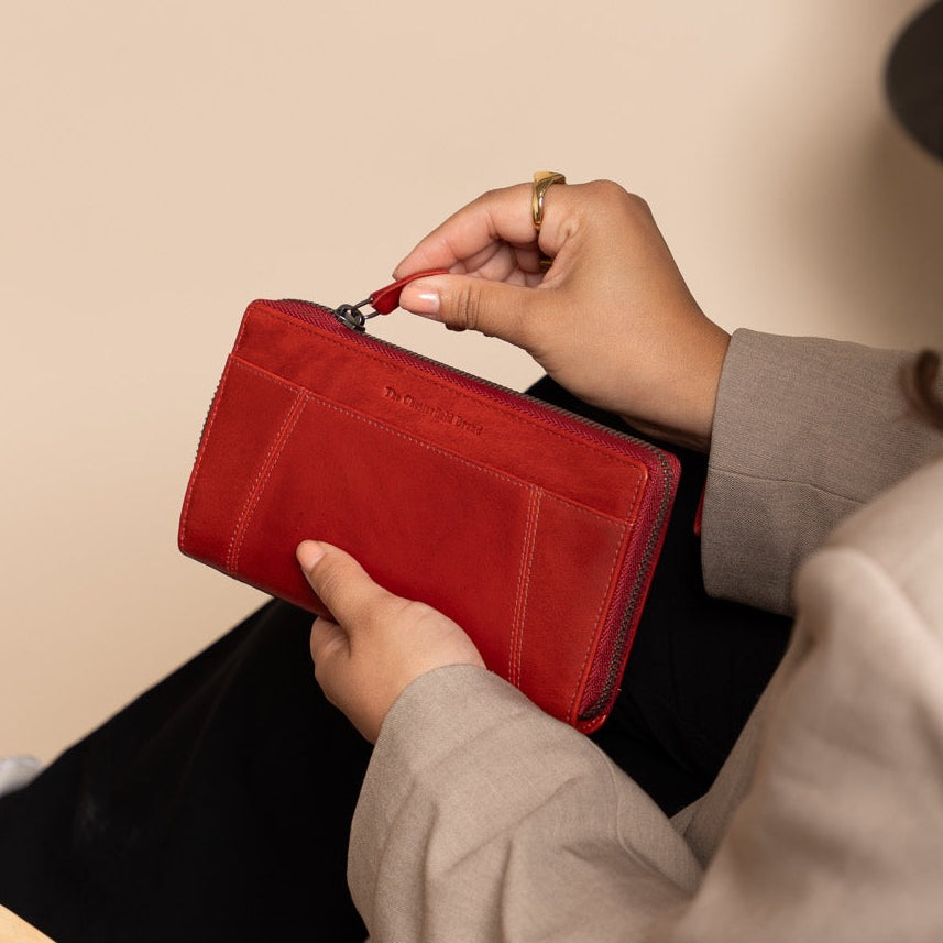 Person holding a red wallet in a casual setting