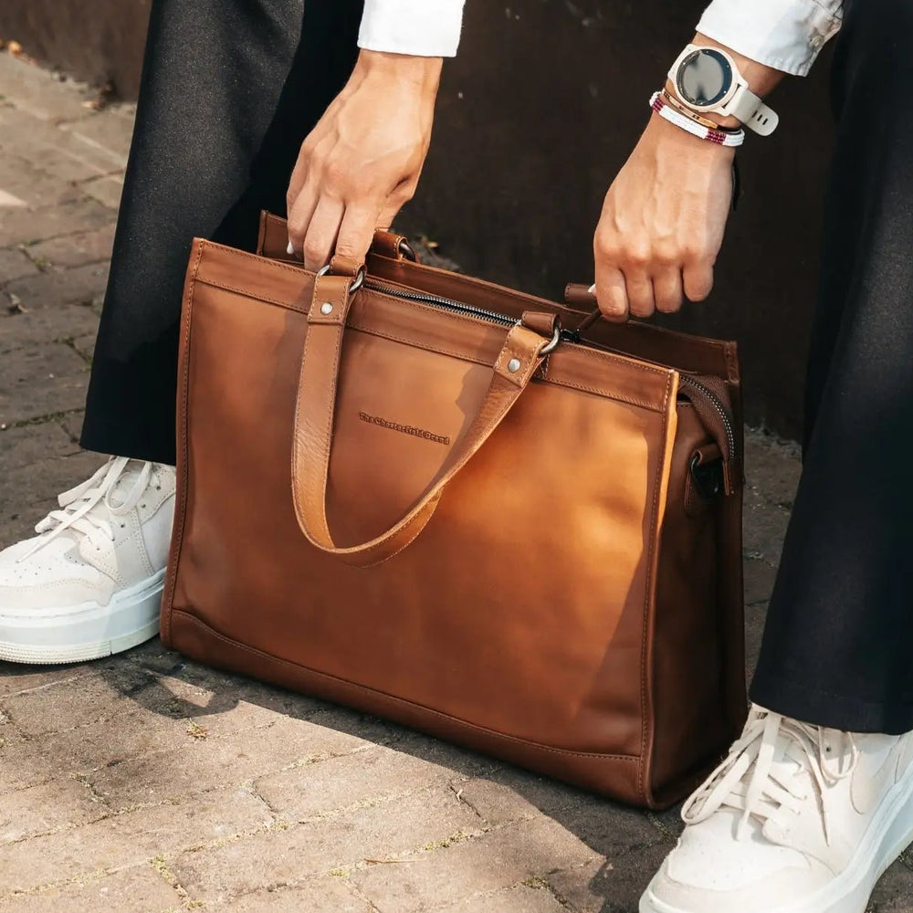 Cognac leather business bag held by a women. 