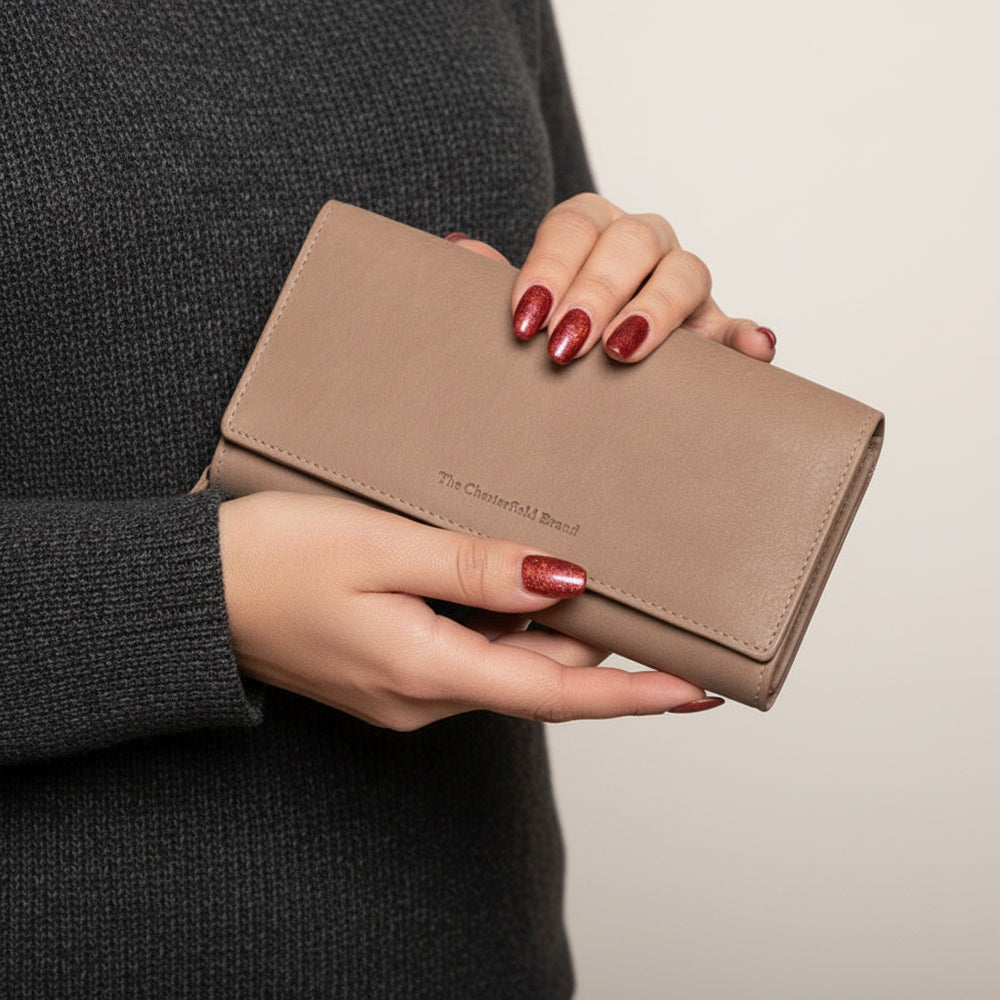 Person holding a beige wallet with a blurred background