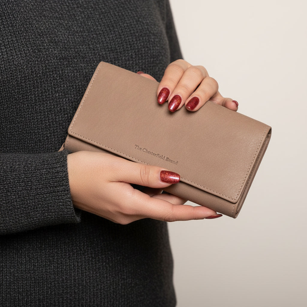 Person holding a beige wallet with a blurred background