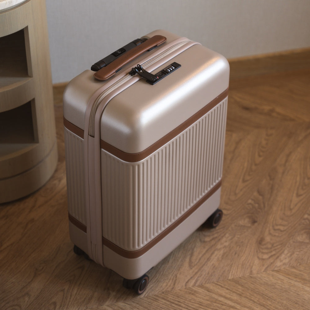 Beige suitcase with brown accents on a wooden floor